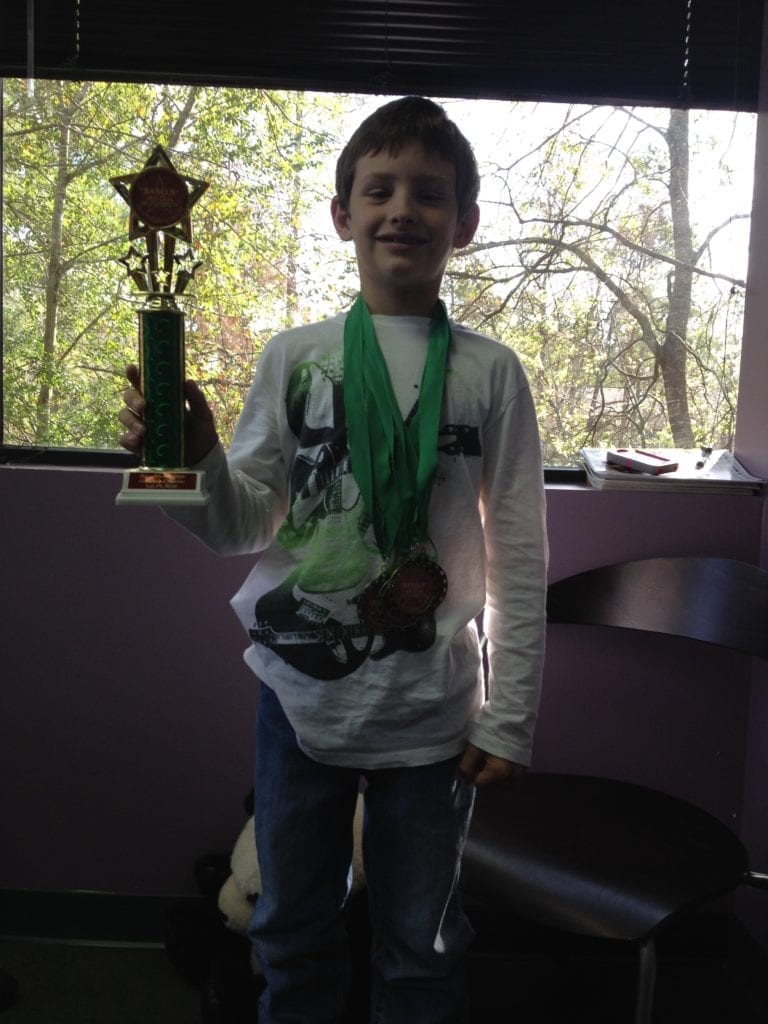 young boy with trophy
